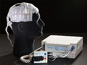 전기장 종양치료기를 머리에 착용한 모형과 주변 장치. 이 장치는 휴대할 수 있고, 일반 전원으로 충전할 수 있다. 현재 미국에서는 FDA 승인 하에 교모세포종 환자의 치료에 사용되고 있다(서울대병원 제공).